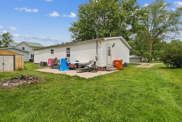 1609 Foraker Ave, Findlay, OH 45840 - rear view of property with a storage unit, entry steps, a patio area, a lawn, and a fire pit