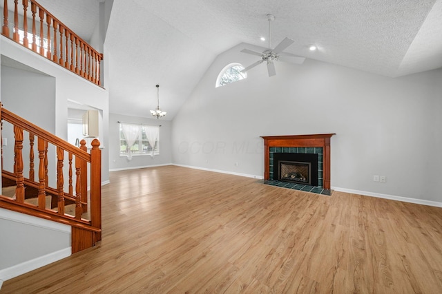 8135 Barlow Rd, Westerville, OH 43081 - unfurnished living room with ceiling fan, high vaulted ceiling, wood finished floors, a chandelier, and a fireplace