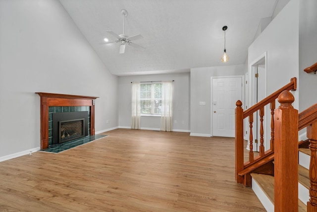 8135 Barlow Rd, Westerville, OH 43081 - unfurnished living room with a ceiling fan, light wood-type flooring, stairs, a fireplace, and high vaulted ceiling