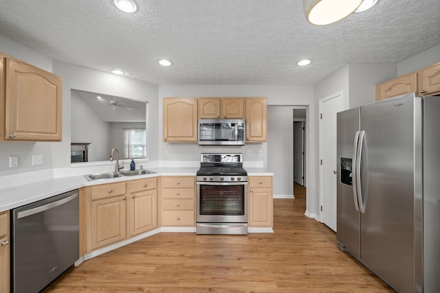 8135 Barlow Rd, Westerville, OH 43081 - kitchen with appliances with stainless steel finishes, light brown cabinets, light wood-style floors, a textured ceiling, and light countertops