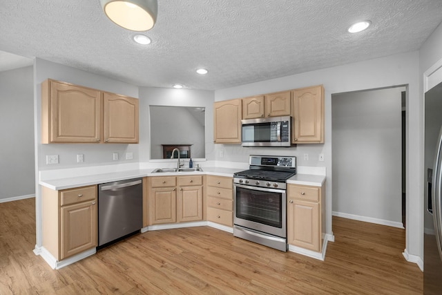 8135 Barlow Rd, Westerville, OH 43081 - kitchen with appliances with stainless steel finishes, light brown cabinets, light countertops, a textured ceiling, and light wood-style flooring