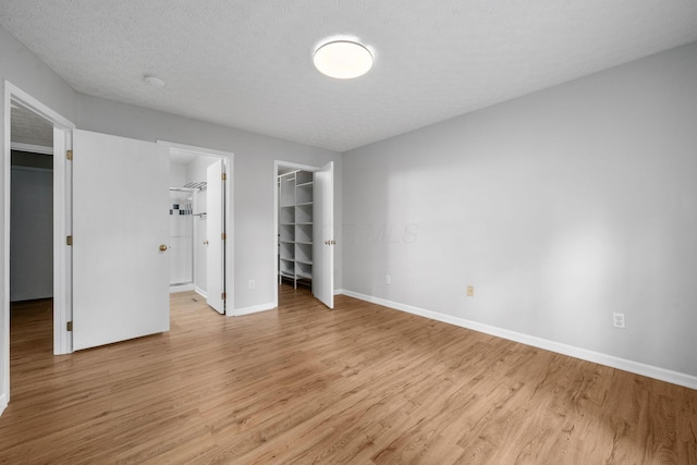8135 Barlow Rd, Westerville, OH 43081 - unfurnished bedroom with a walk in closet, a closet, light wood-style flooring, and connected bathroom