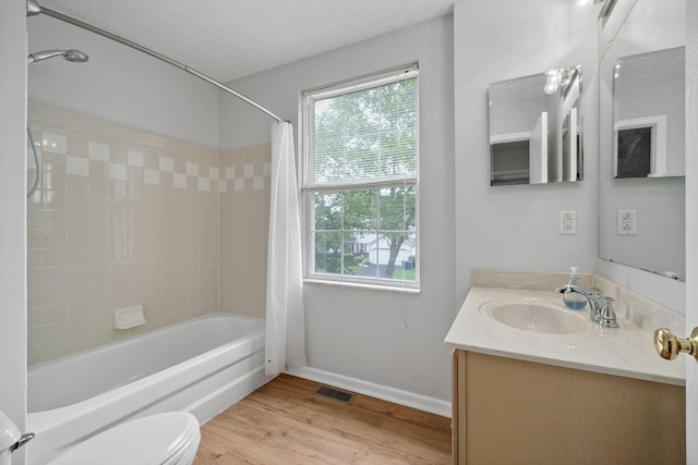 8135 Barlow Rd, Westerville, OH 43081 - full bathroom with vanity, shower / bath combination with curtain, healthy amount of natural light, wood finished floors, and a textured ceiling