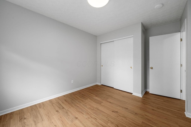 8135 Barlow Rd, Westerville, OH 43081 - unfurnished bedroom with light wood-type flooring, a closet, and a textured ceiling