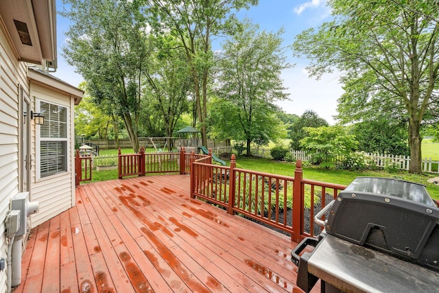 8135 Barlow Rd, Westerville, OH 43081 - wooden deck featuring a fenced backyard, area for grilling, a playground, and view of scattered trees