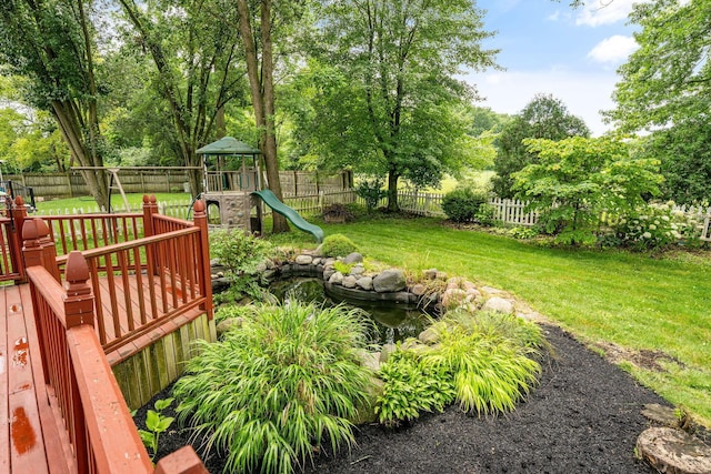 8135 Barlow Rd, Westerville, OH 43081 - fenced backyard featuring a playground, a small pond, and view of wooded area