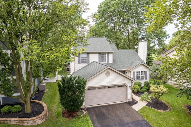 8135 Barlow Rd, Westerville, OH 43081 - view of front of house with driveway, a garage, a chimney, and roof with shingles