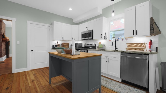 737 Wilson Ave, Columbus, OH 43205 - kitchen with appliances with stainless steel finishes, butcher block countertops, tasteful backsplash, wood finished floors, and recessed lighting