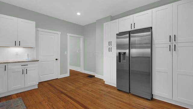 737 Wilson Ave, Columbus, OH 43205 - kitchen with stainless steel fridge, wood finished floors, white cabinetry, decorative backsplash, and light stone counters