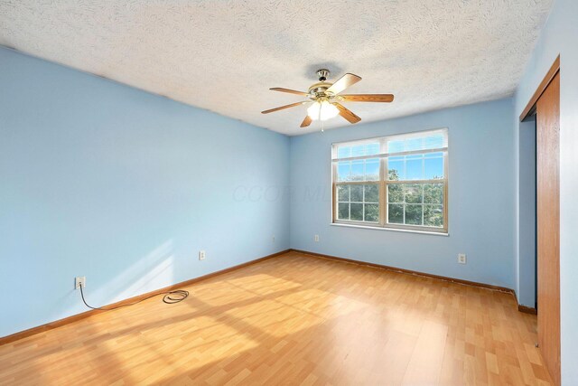 3576 Blendon Bend Way, Columbus, OH 43231 - unfurnished bedroom with light wood-style floors, a textured ceiling, a closet, and a ceiling fan