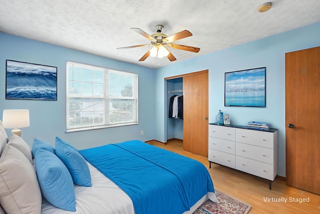 3576 Blendon Bend Way, Columbus, OH 43231 - bedroom featuring light wood finished floors, a closet, a textured ceiling, and ceiling fan