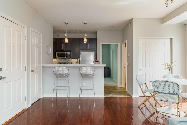 115 E Noble St Unit 2, Columbus, OH 43215 - kitchen featuring appliances with stainless steel finishes, light countertops, track lighting, backsplash, and dark wood-style floors