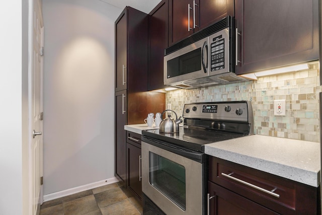 115 E Noble St Unit 2, Columbus, OH 43215 - kitchen featuring stainless steel appliances, backsplash, dark brown cabinets, and light stone countertops