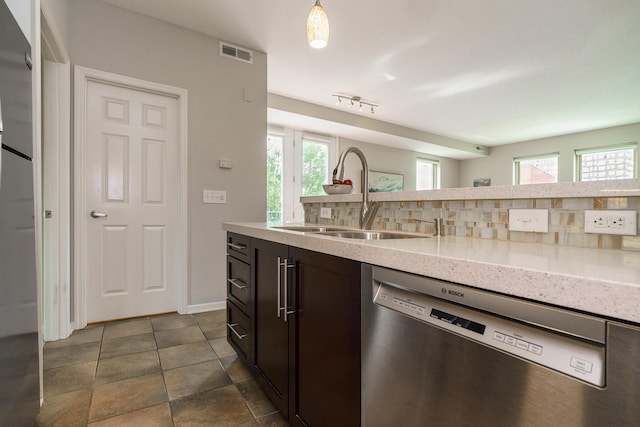 115 E Noble St Unit 2, Columbus, OH 43215 - kitchen featuring stainless steel dishwasher, decorative backsplash, plenty of natural light, and light stone countertops
