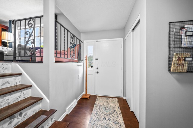 3221 E Hudson St, Columbus, OH 43219 - entryway featuring wood finished floors, stairs, and a textured ceiling