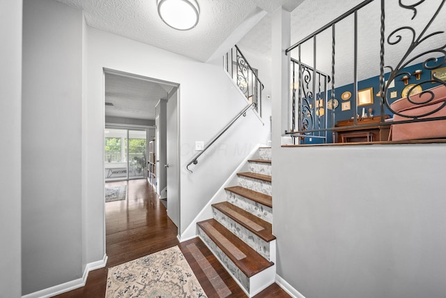 3221 E Hudson St, Columbus, OH 43219 - staircase with wood finished floors and a textured ceiling