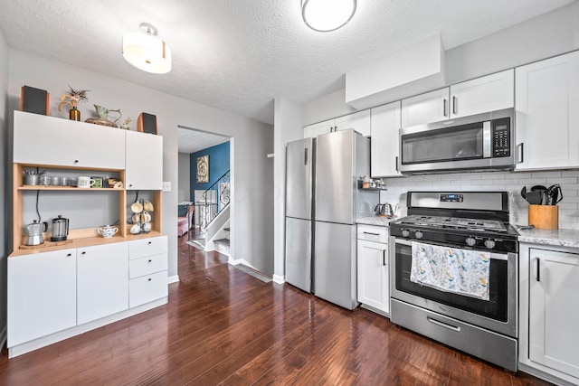 3221 E Hudson St, Columbus, OH 43219 - kitchen with appliances with stainless steel finishes, open shelves, decorative backsplash, a textured ceiling, and white cabinets