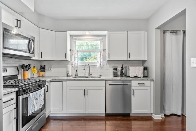 3221 E Hudson St, Columbus, OH 43219 - kitchen with appliances with stainless steel finishes, tasteful backsplash, and white cabinetry