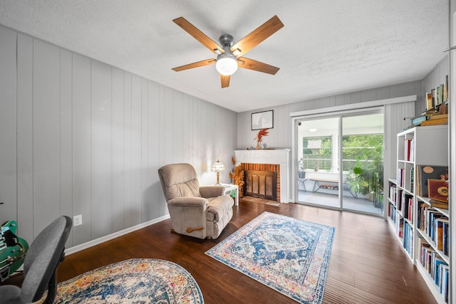 3221 E Hudson St, Columbus, OH 43219 - living area with a ceiling fan, wood finished floors, a textured ceiling, and a fireplace