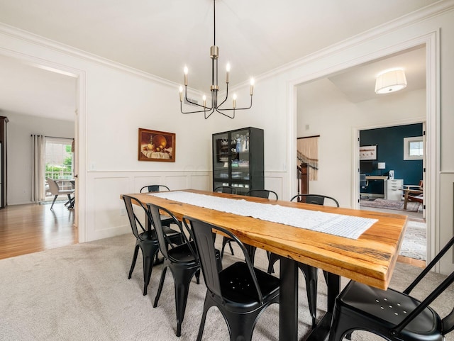 5808 Glendavon Loop, Dublin, OH 43016 - dining room featuring crown molding, light carpet, a chandelier, a decorative wall, and a wainscoted wall