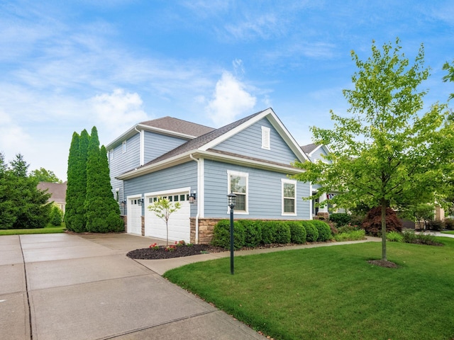 5808 Glendavon Loop, Dublin, OH 43016 - view of property exterior featuring concrete driveway, a yard, a garage, and stone siding