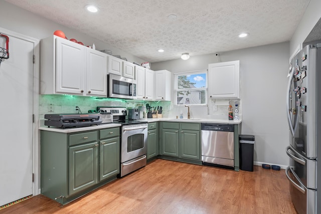 2986 E Powell Rd, Columbus, OH 43240 - kitchen featuring appliances with stainless steel finishes, green cabinets, white cabinetry, backsplash, and recessed lighting