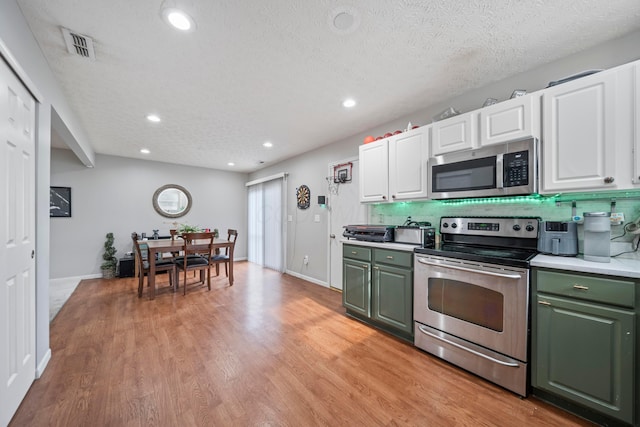 2986 E Powell Rd, Columbus, OH 43240 - kitchen featuring appliances with stainless steel finishes, green cabinets, white cabinets, light wood-style flooring, and light countertops