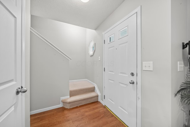 2986 E Powell Rd, Columbus, OH 43240 - entrance foyer with stairs, light wood-style floors, and a textured ceiling