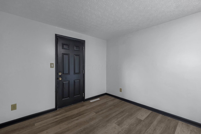 4974 Silverton Dr, Columbus, OH 43232 - empty room with dark wood finished floors and a textured ceiling