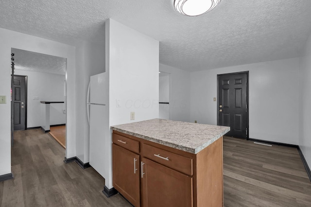 4974 Silverton Dr, Columbus, OH 43232 - kitchen with a textured ceiling, dark wood finished floors, freestanding refrigerator, light countertops, and brown cabinetry