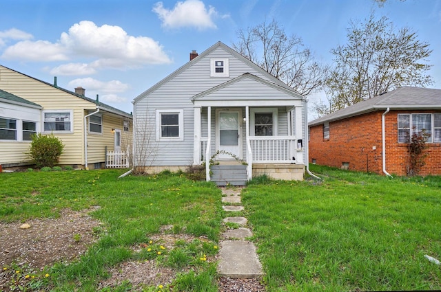 2678 Eakin Rd, Columbus, OH 43204 - view of front facade with covered porch, a front lawn, and a chimney