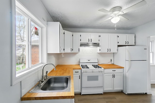 2678 Eakin Rd, Columbus, OH 43204 - kitchen with white appliances, butcher block countertops, under cabinet range hood, a textured ceiling, and a ceiling fan