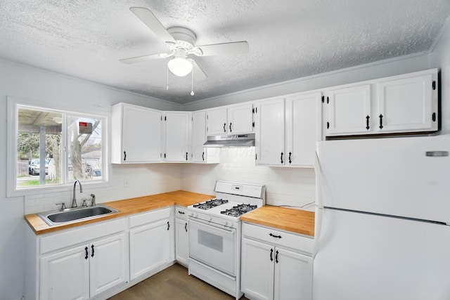 2678 Eakin Rd, Columbus, OH 43204 - kitchen featuring white appliances, under cabinet range hood, a textured ceiling, wooden counters, and white cabinets