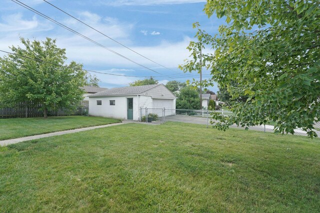 5335 Crawford Dr, Columbus, OH 43229 - fenced backyard featuring a detached garage and an outbuilding