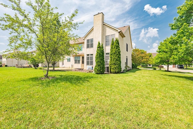 8510 Morgan St, Pickerington, OH 43147 - rear view of house featuring stucco siding, a chimney, and a yard