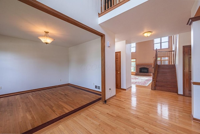8510 Morgan St, Pickerington, OH 43147 - empty room with stairs, light wood-style flooring, and a fireplace
