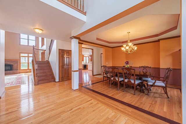 8510 Morgan St, Pickerington, OH 43147 - dining room featuring a fireplace, wood finished floors, stairway, a chandelier, and a raised ceiling