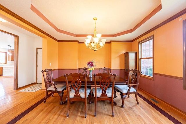 8510 Morgan St, Pickerington, OH 43147 - dining space with a tray ceiling, wood finished floors, a chandelier, and ornamental molding