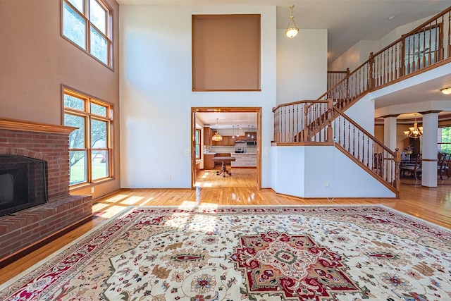 8510 Morgan St, Pickerington, OH 43147 - living area with a towering ceiling, plenty of natural light, wood finished floors, a chandelier, and a brick fireplace