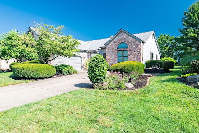 5608 Lynx Dr, Westerville, OH 43081 - view of front of home featuring a garage, driveway, a front lawn, and brick siding