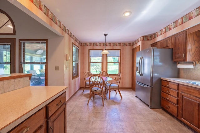 5608 Lynx Dr, Westerville, OH 43081 - kitchen featuring stainless steel fridge, brown cabinetry, light countertops, and pendant lighting
