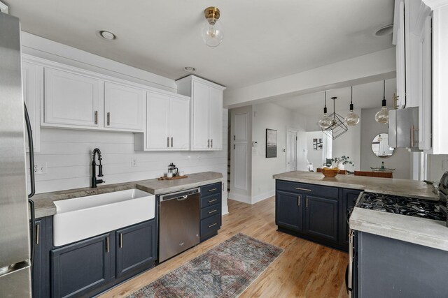 442 Thurman Ave, Columbus, OH 43206 - kitchen featuring stainless steel appliances, blue cabinets, white cabinetry, light wood-style floors, and a peninsula