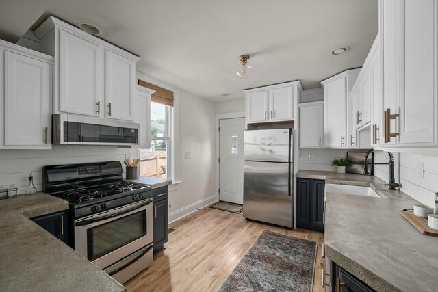 442 Thurman Ave, Columbus, OH 43206 - kitchen featuring appliances with stainless steel finishes, white cabinets, light countertops, light wood-style flooring, and recessed lighting