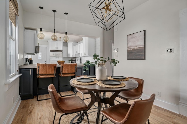 442 Thurman Ave, Columbus, OH 43206 - dining room with light wood-style flooring and a chandelier