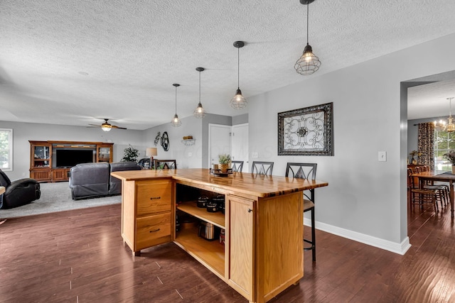 1626 Geranium Dr, Lewis Center, OH 43035 - kitchen featuring wood counters, a textured ceiling, dark wood-type flooring, and a breakfast bar