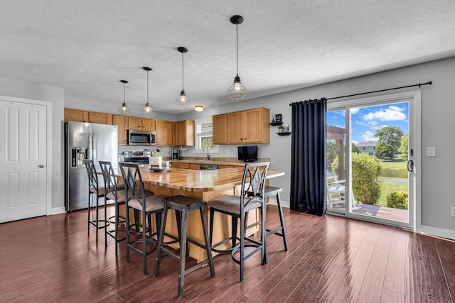 1626 Geranium Dr, Lewis Center, OH 43035 - kitchen with appliances with stainless steel finishes, butcher block countertops, a textured ceiling, dark wood-style flooring, and hanging light fixtures