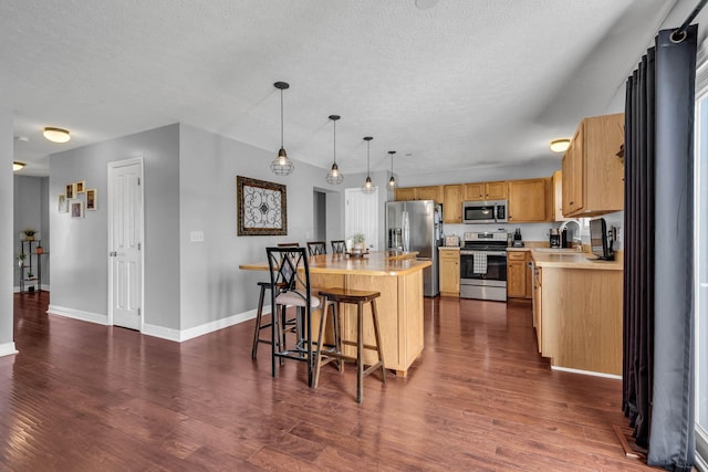 1626 Geranium Dr, Lewis Center, OH 43035 - kitchen with stainless steel appliances, light countertops, a center island, dark wood-style floors, and a textured ceiling