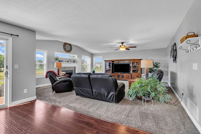 1626 Geranium Dr, Lewis Center, OH 43035 - living room with a tile fireplace, wood finished floors, a ceiling fan, a textured ceiling, and vaulted ceiling