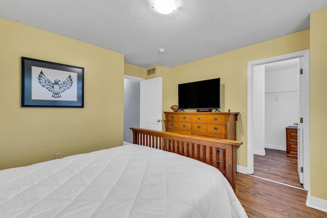 1626 Geranium Dr, Lewis Center, OH 43035 - bedroom with wood finished floors, a textured ceiling, and a spacious closet