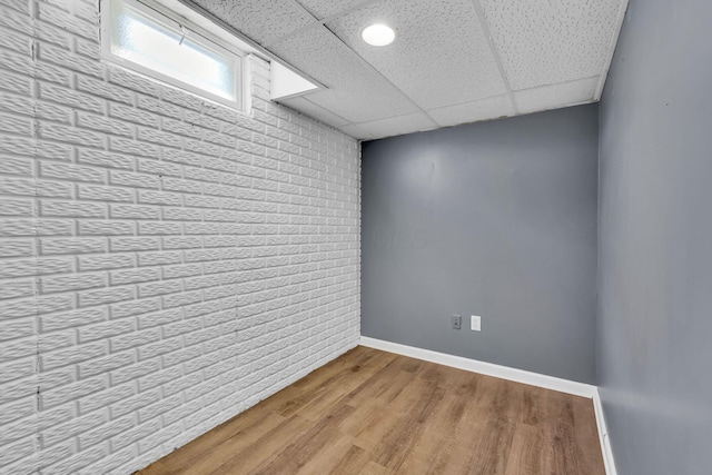1626 Geranium Dr, Lewis Center, OH 43035 - unfurnished room with brick wall, light wood-type flooring, and a drop ceiling